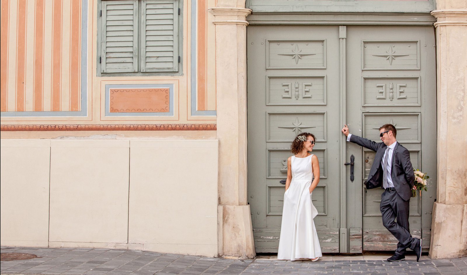 Esküvők, szertartások fotózása budapesten, a vőlegény virágcsokrot visz a menyasszonynak