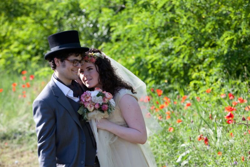 A menyasszony szerelmesen néz a vőlegényre pipacsok között