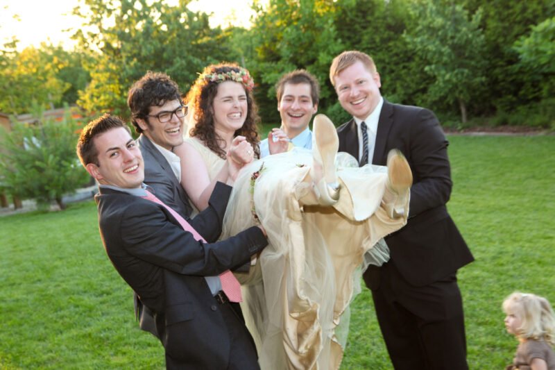 A csoport képek vicces eleme, amikor a férfiak felemelik a menyasszonyt